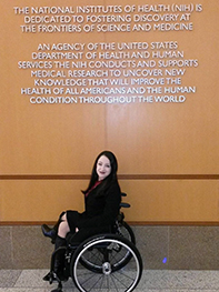 Kristal posa para una fotografía en su silla de ruedas mientras visita los NIH.